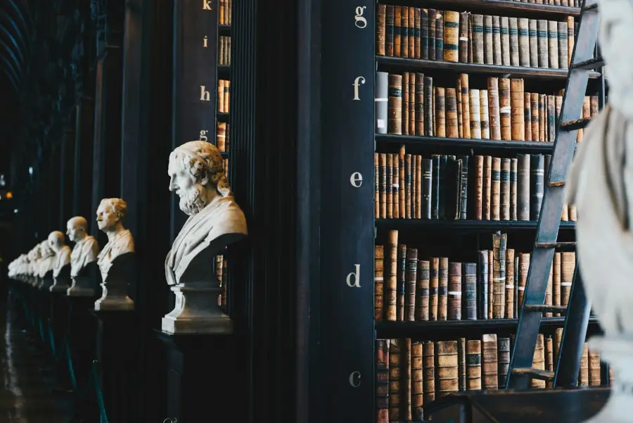 Biblioteca clássica com bustos e livros jurídicos